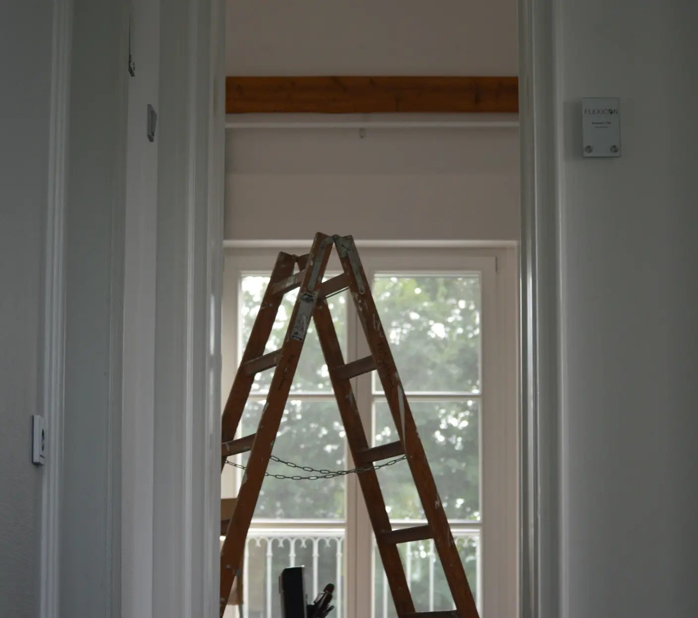 A set of ladders placed in a room that is undergoing a renovation.