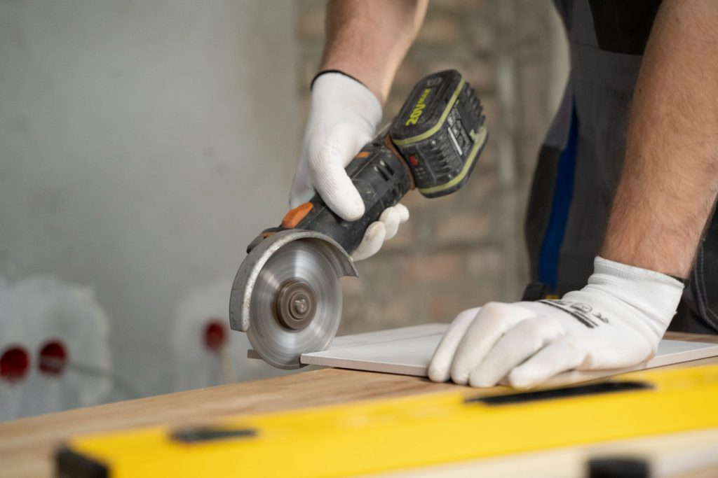 A construction worker cutting tiles with a circular saw for a bathroom renovation.