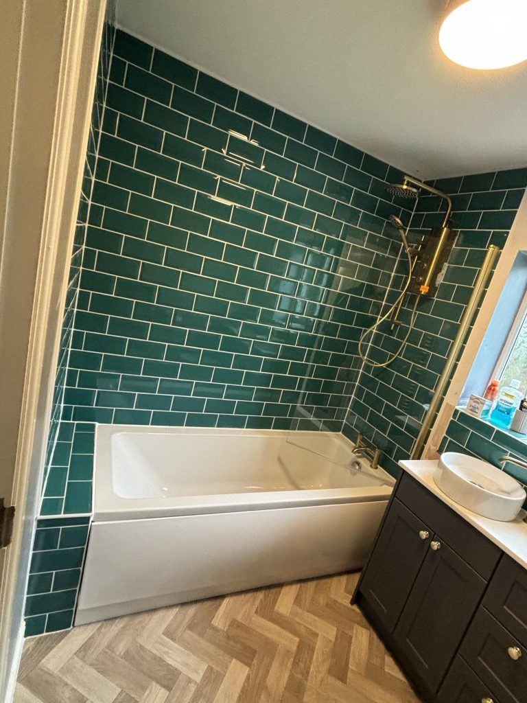 A bespoke bathroom refurbishment featuring trendy emerald tiles.